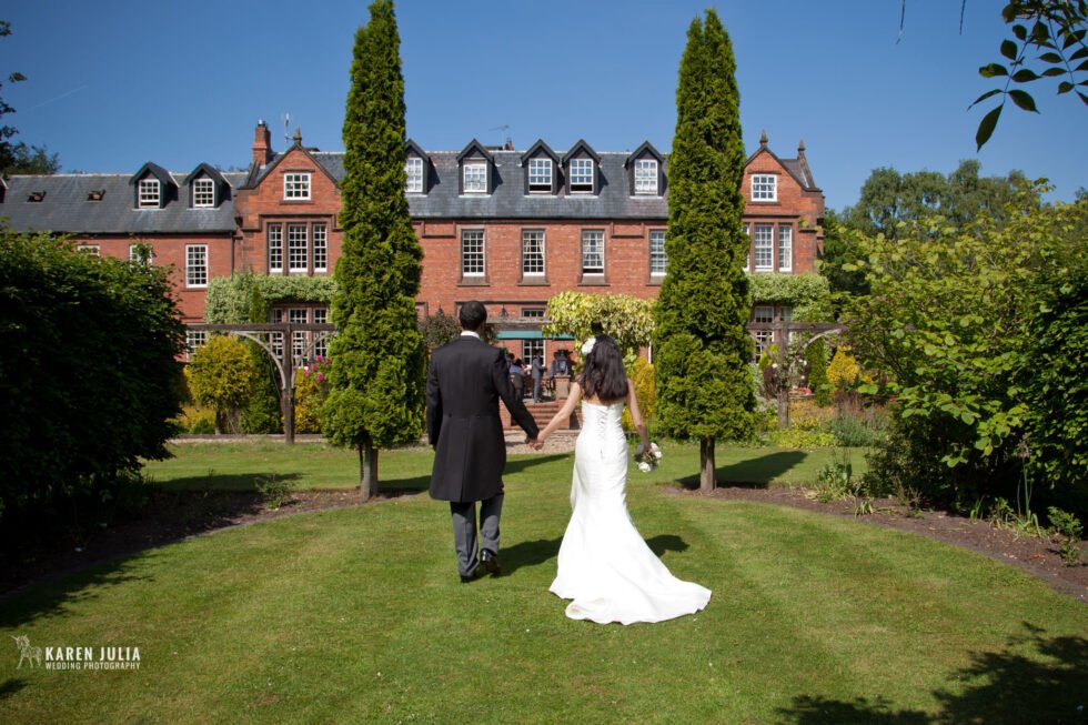 bride and groom walk hand in hand at their Alice in Wonderland themed wedding