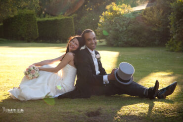bride and groom sit on the ground back to back at their Alice in Wonderland wedding