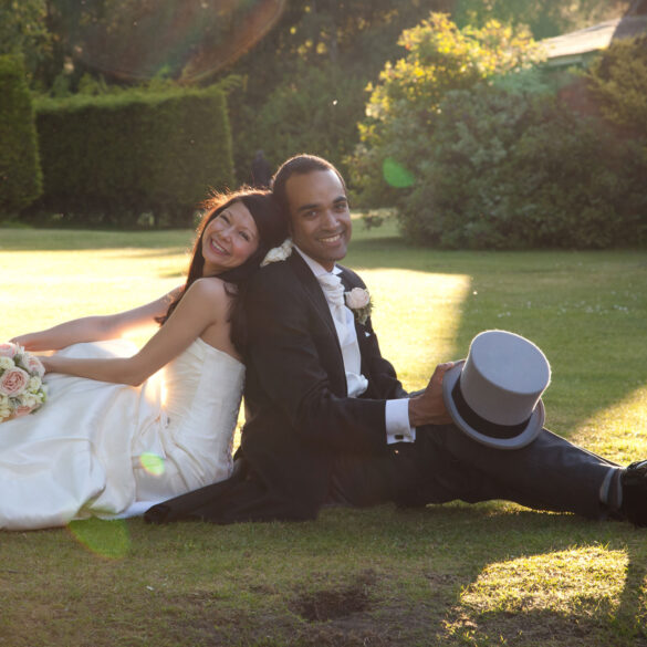 bride and groom sit on the ground back to back at their Alice in Wonderland wedding