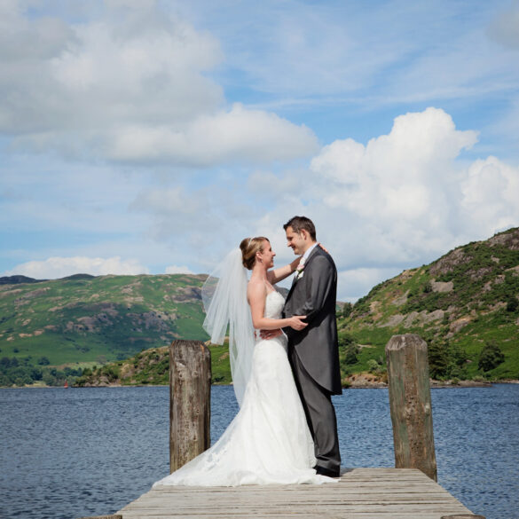 bride and groom stand together on the ier at their inn on the lake wedding