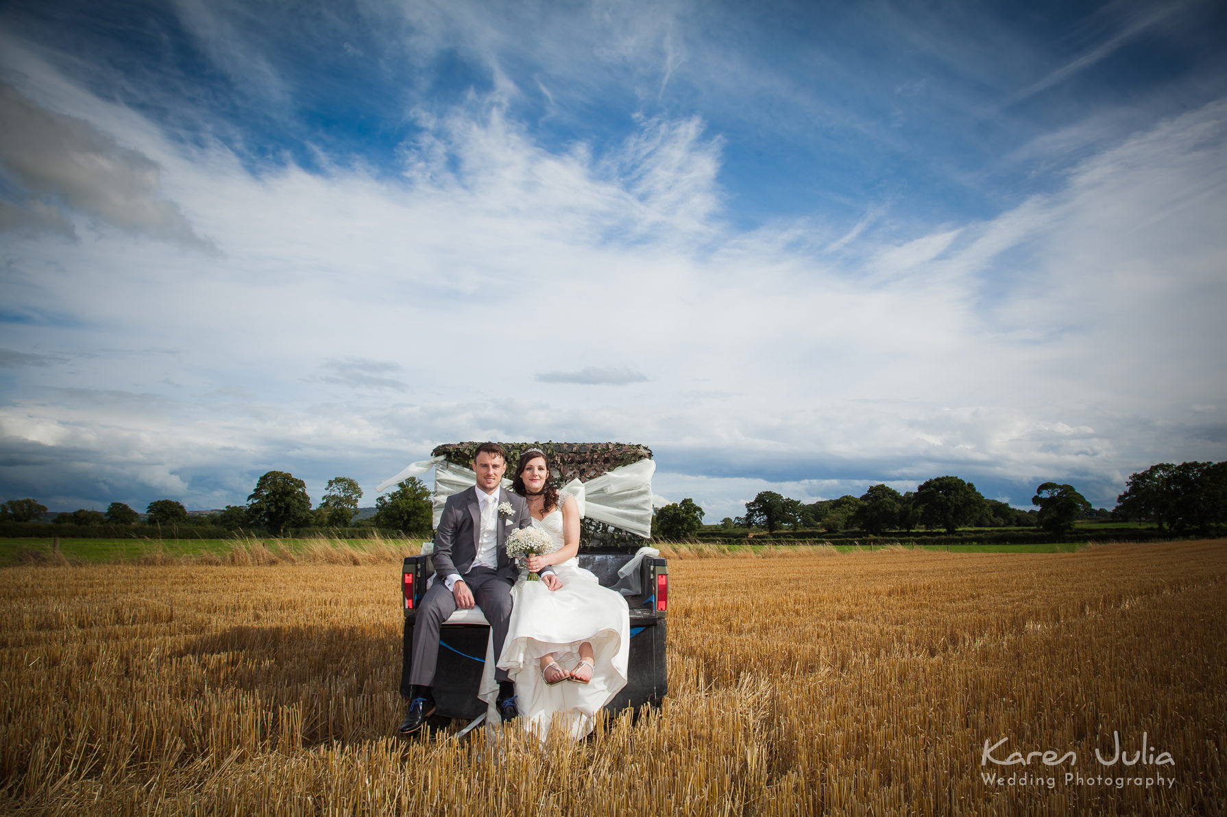 bride and groom on buggy in cornfield on wedding day