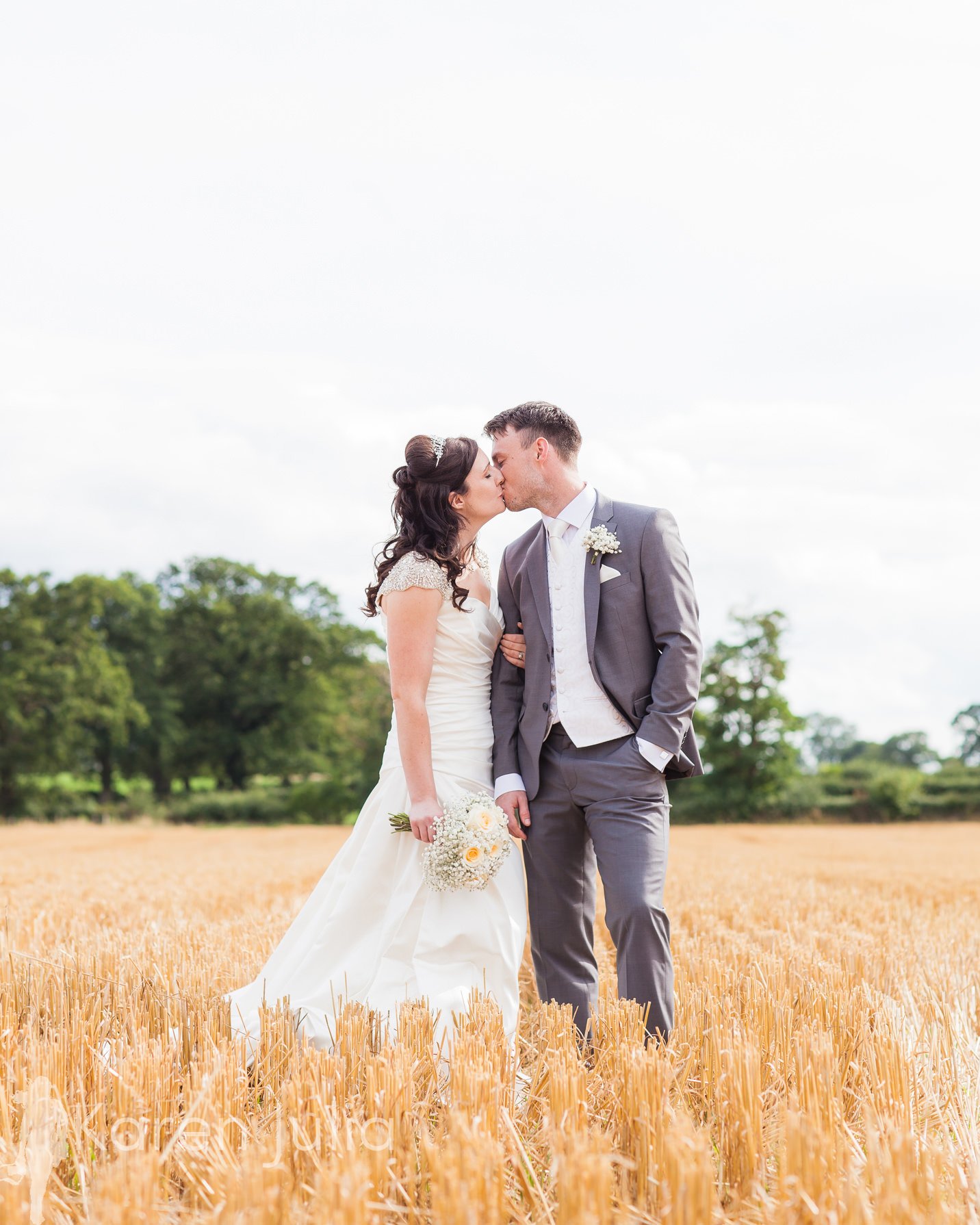 bride and groom in freshly cut cornfield , Cheshire