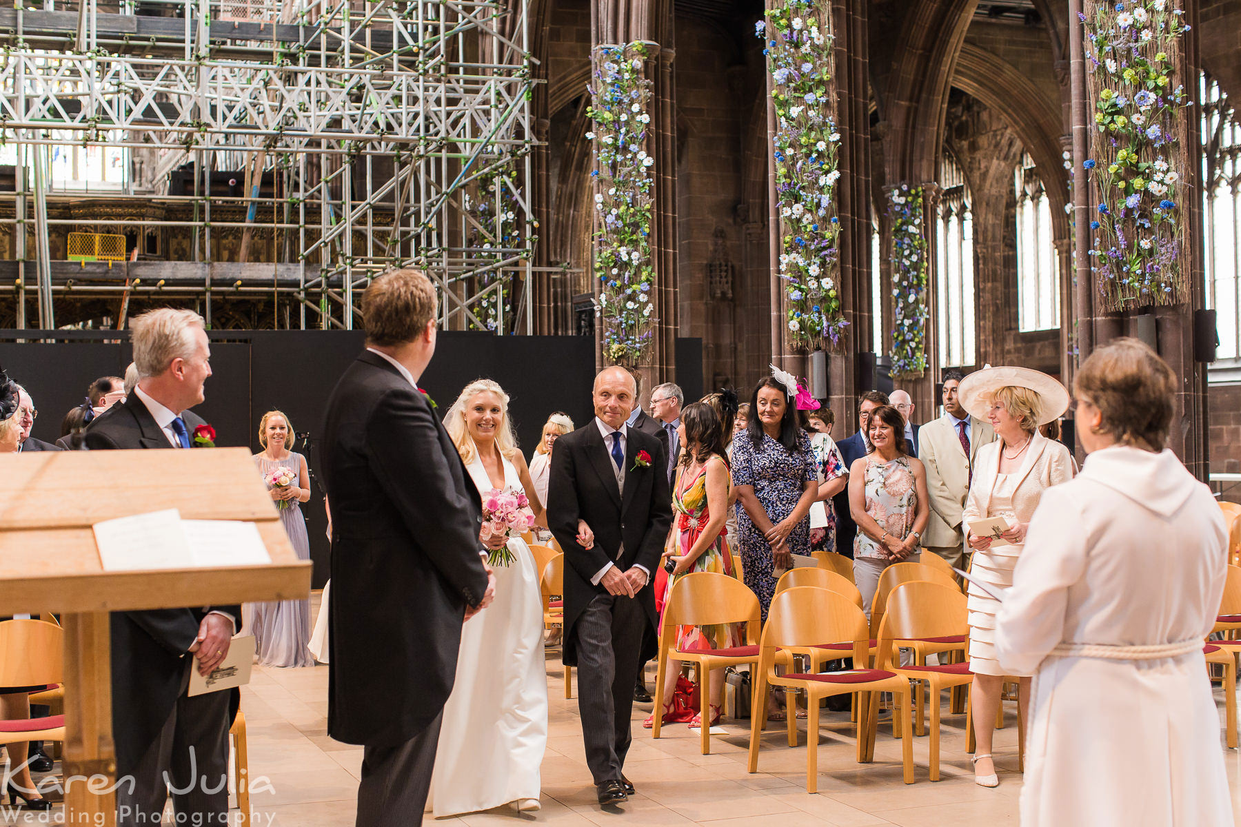 bride walks down the aisle to meet the groom with her dad at Manchester Cathedral 