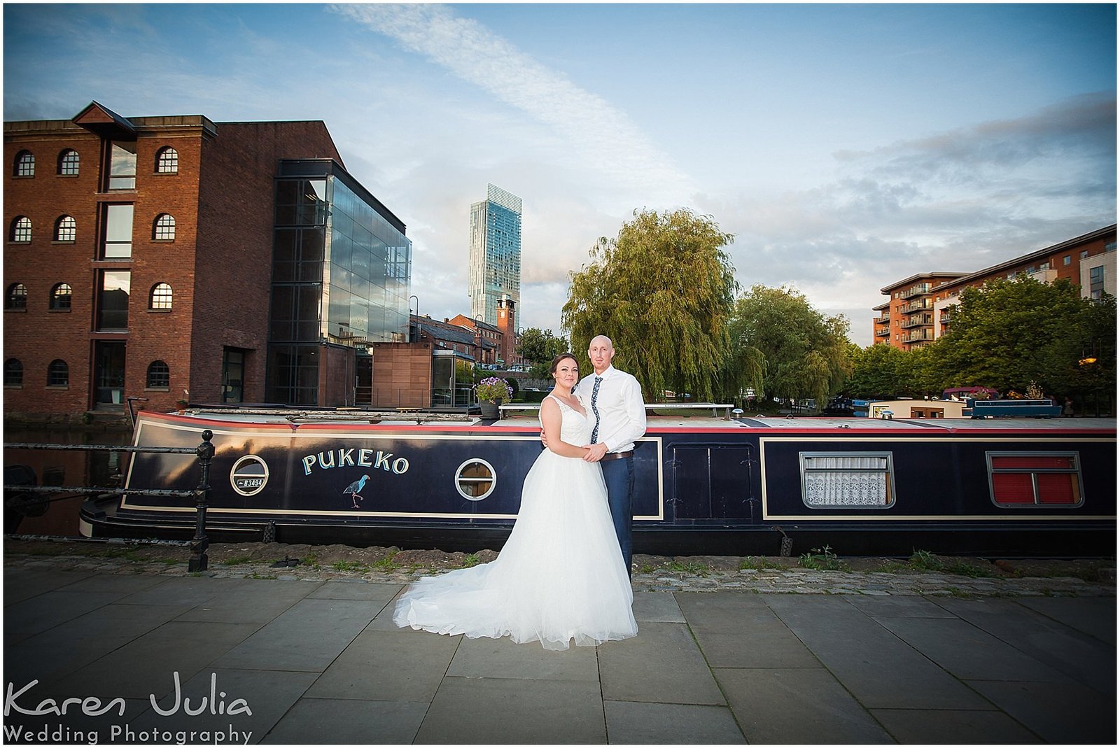 bride and groom pose for a wedding day portrait in Castlefield with canal in background