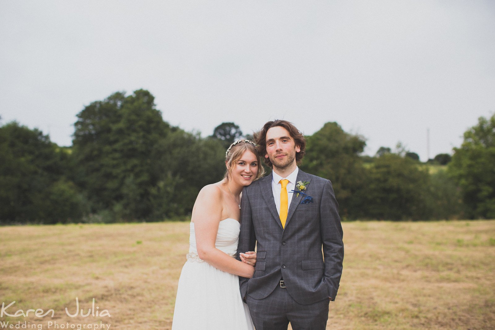 Rustic Village Hall Wedding Photography featuring bride and groom in field