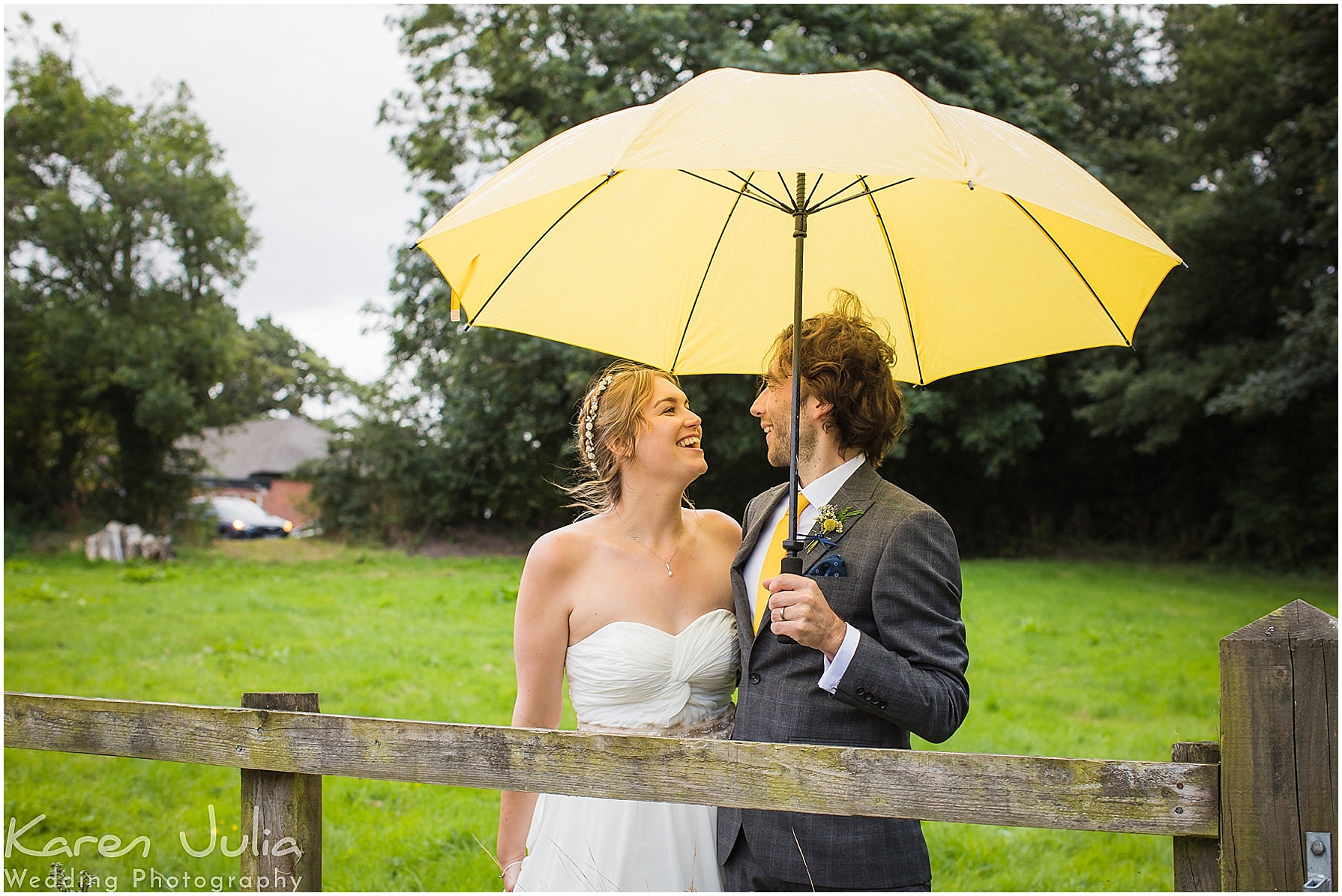 bride and groom with yellow umbrella in the rain on their wedding day