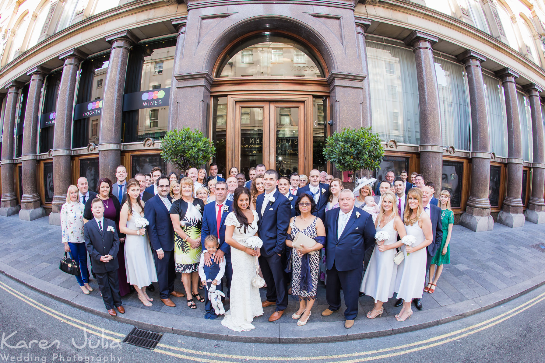 a full wedding group photo of everyone outside the hard days night hotel