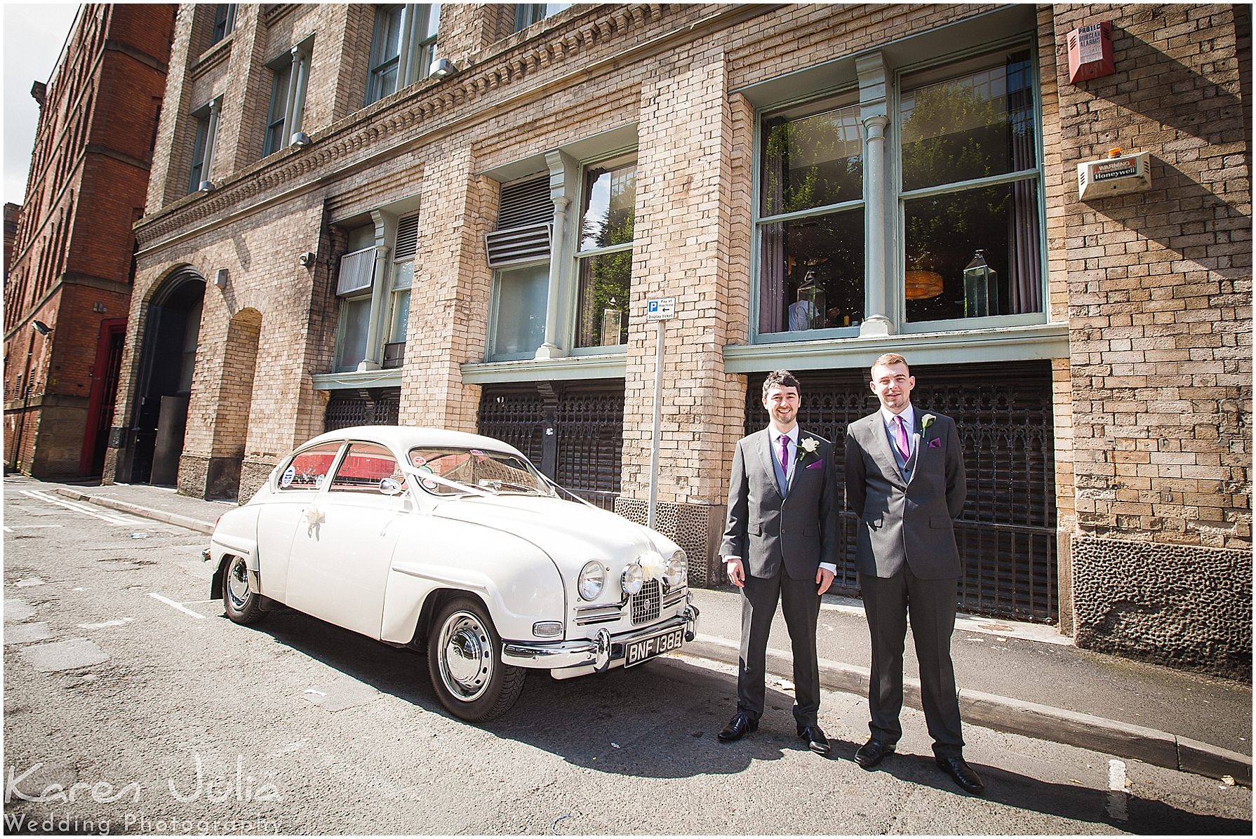 groom and best man pose next to cream vintage Saab