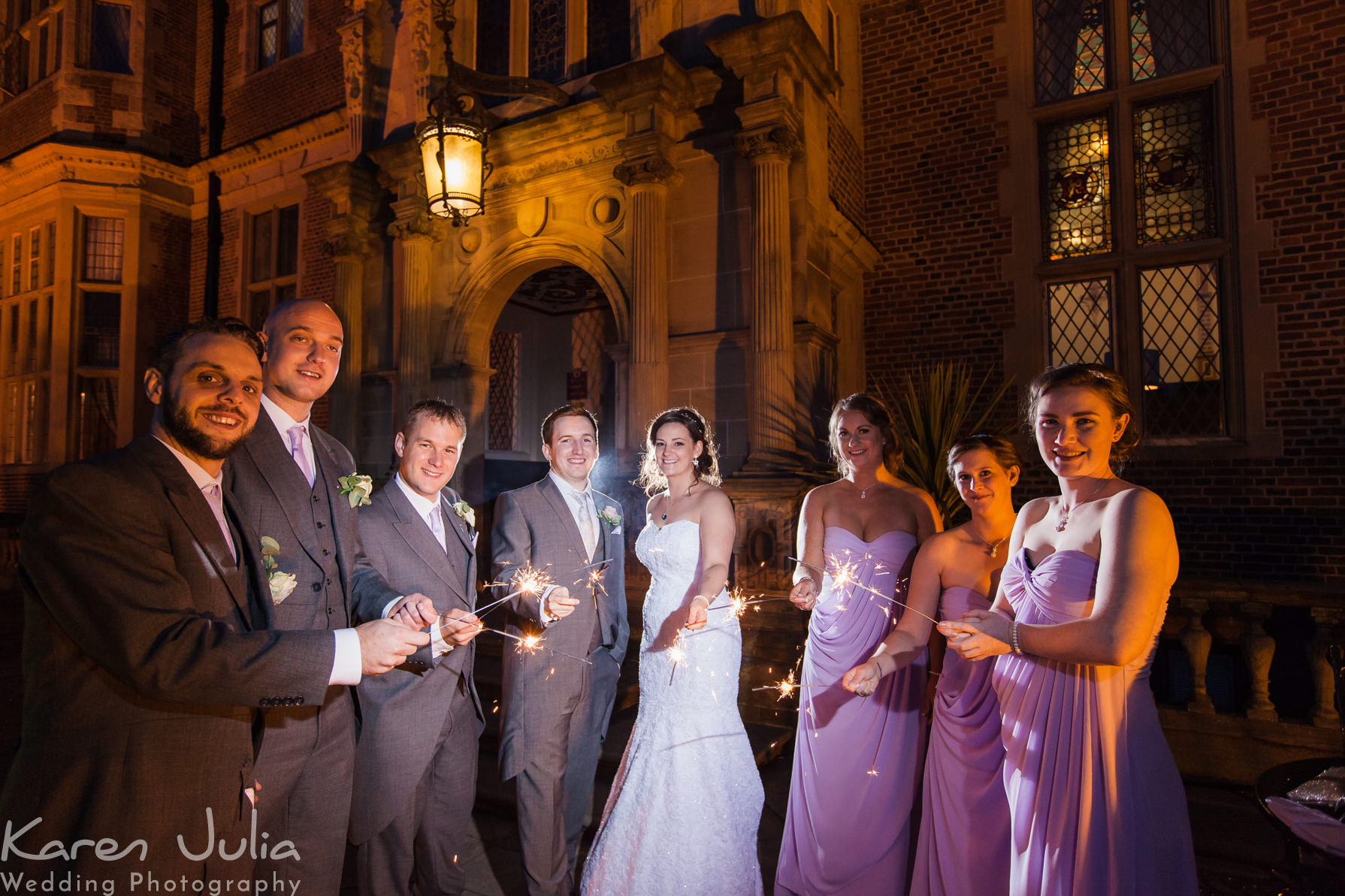 bride and groom with bridesmaids and uhers with sparklers