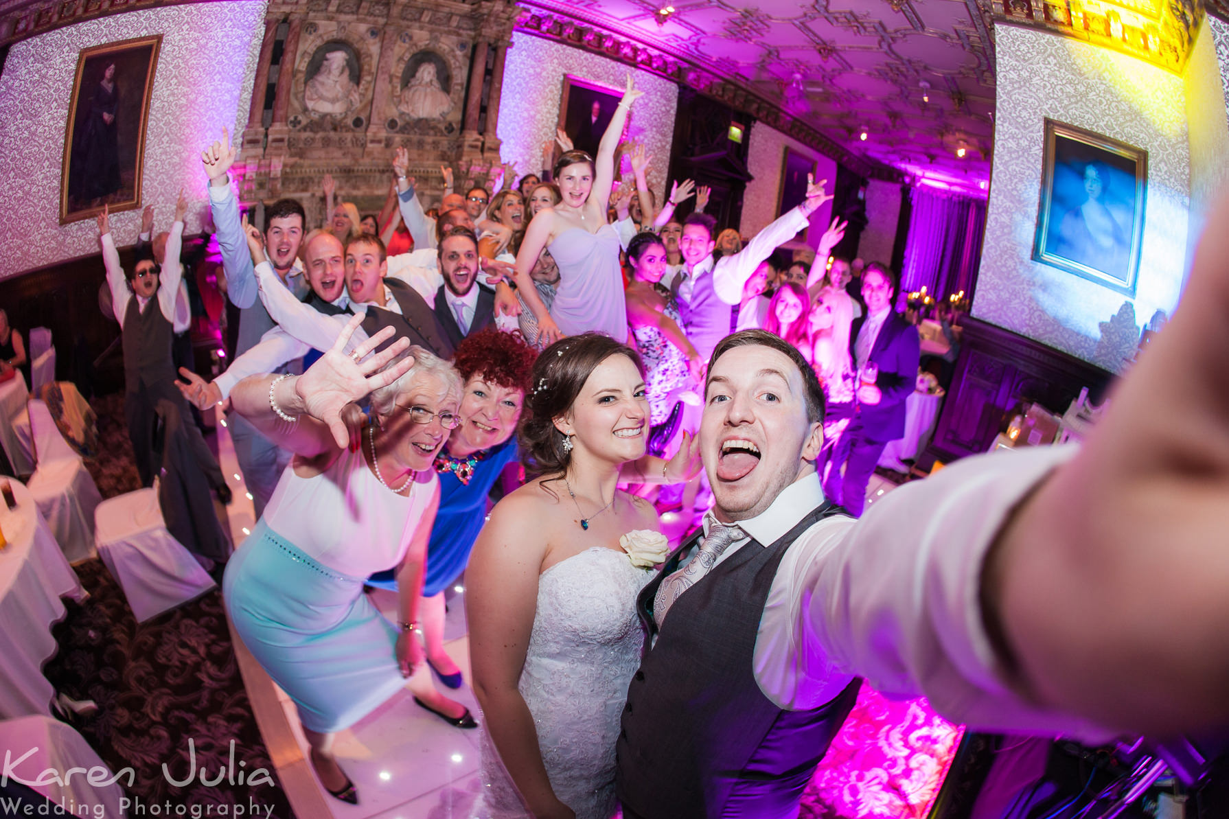 bride and groom group shot selfie on the dance floor at the end of the night