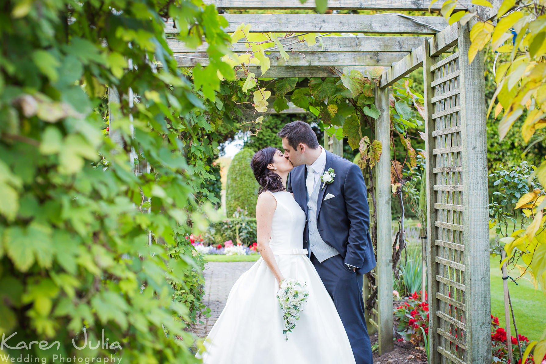 bride and groom kiss in the gardens of Mottram Hall