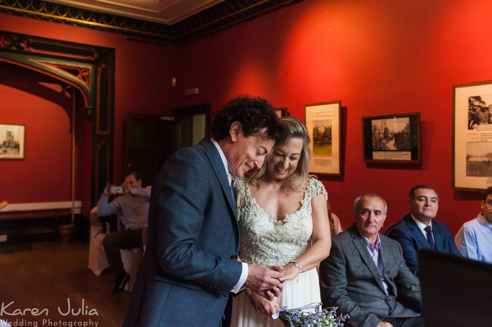 bride and groom exchange rings during wedding ceremony in Didsbury Parsonage