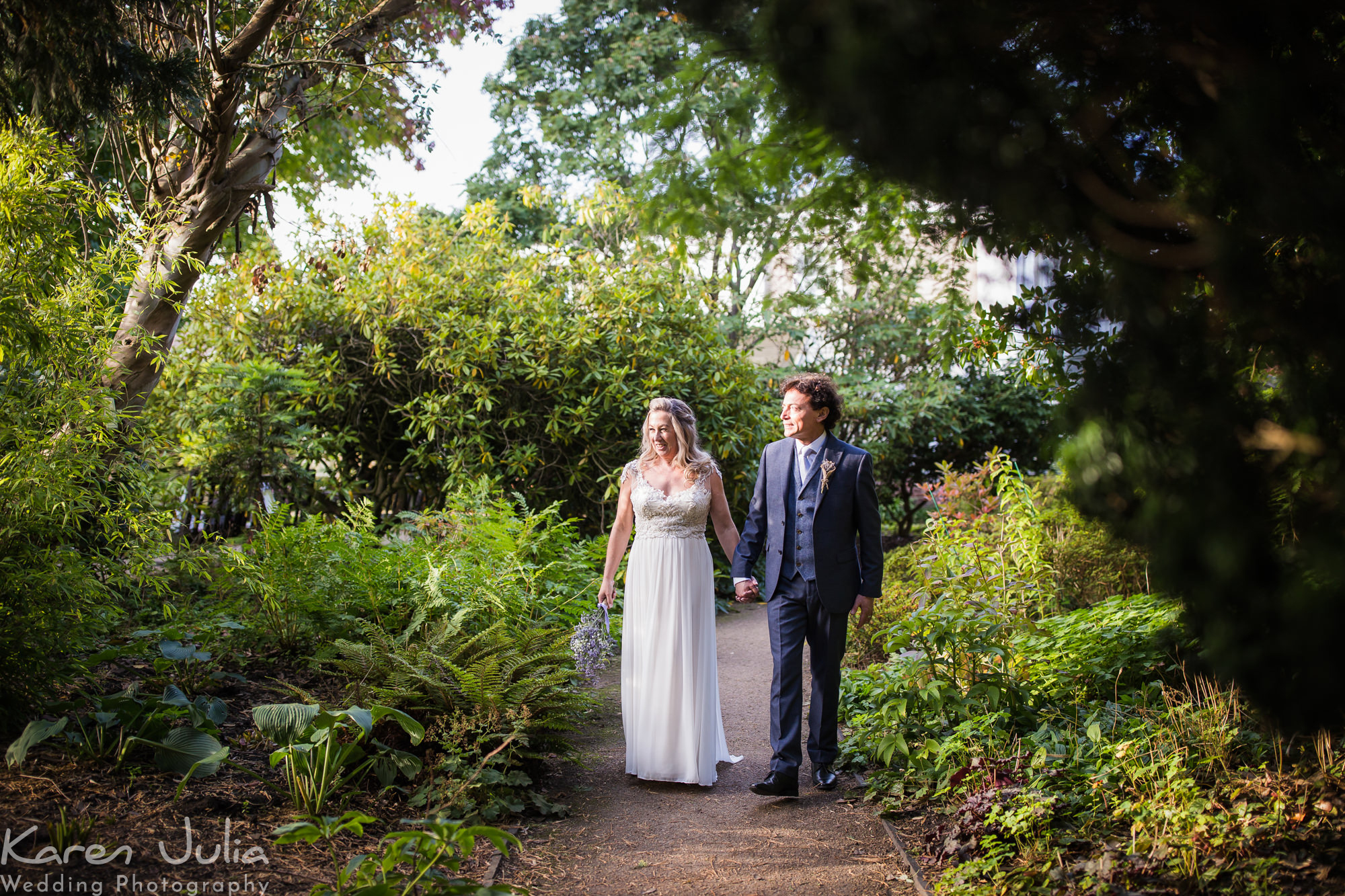 bride and groom walk in Parsonage gardens in the sunlight