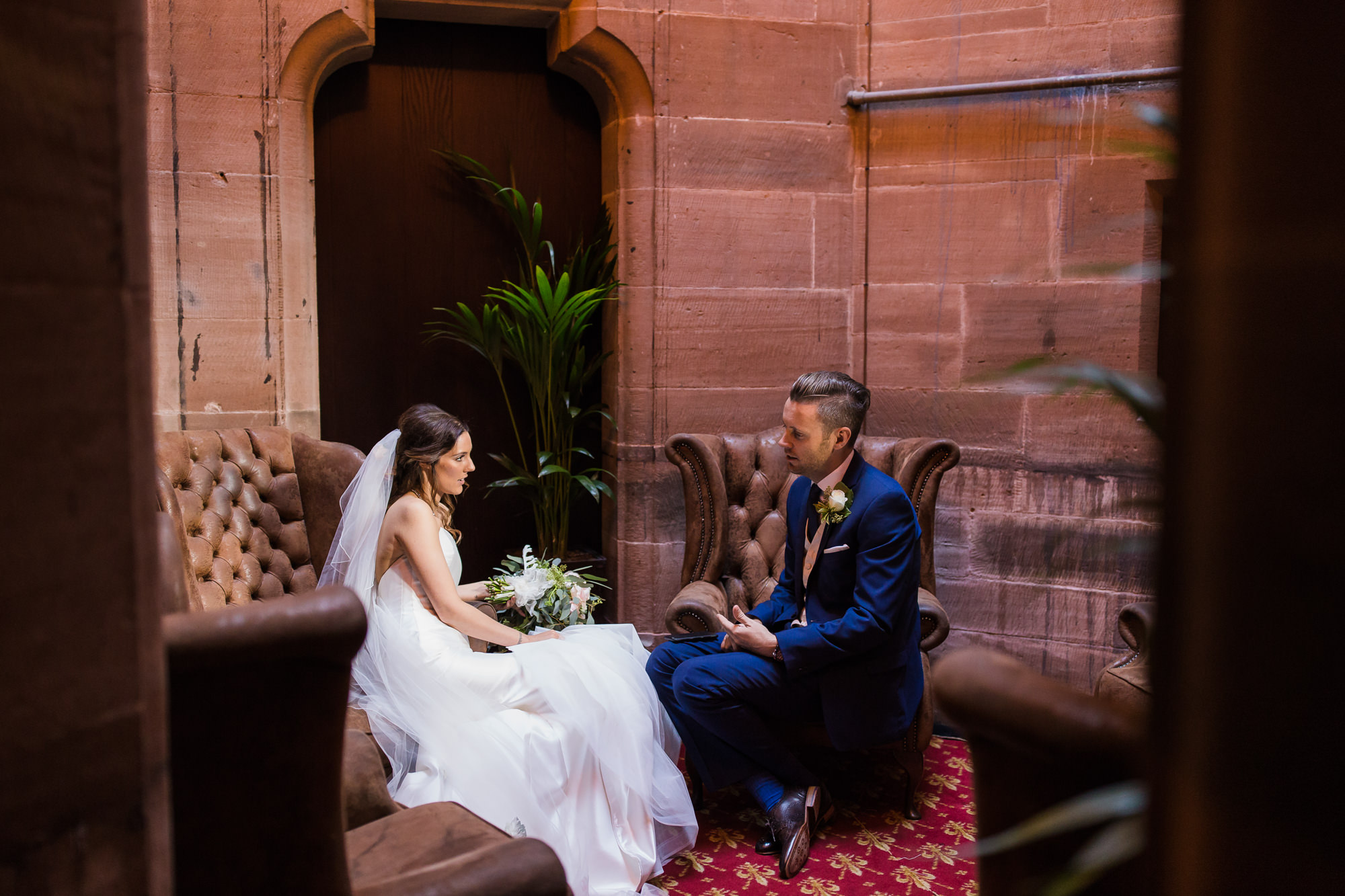 bride and groom sitting chatting in Peckforton Castle