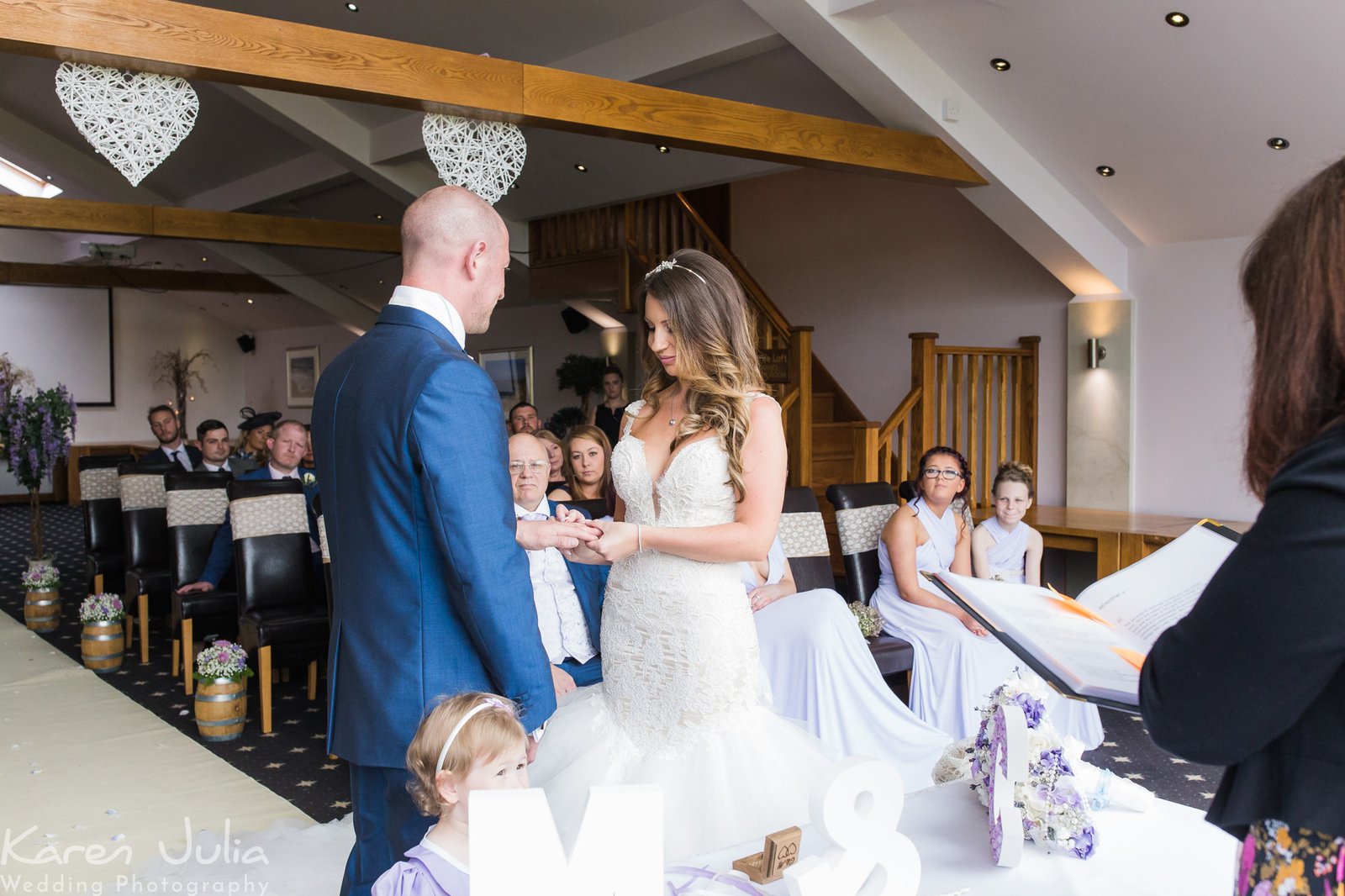 bride places ring on grooms finger during wedding ceremony at The Fisherman's Retreat