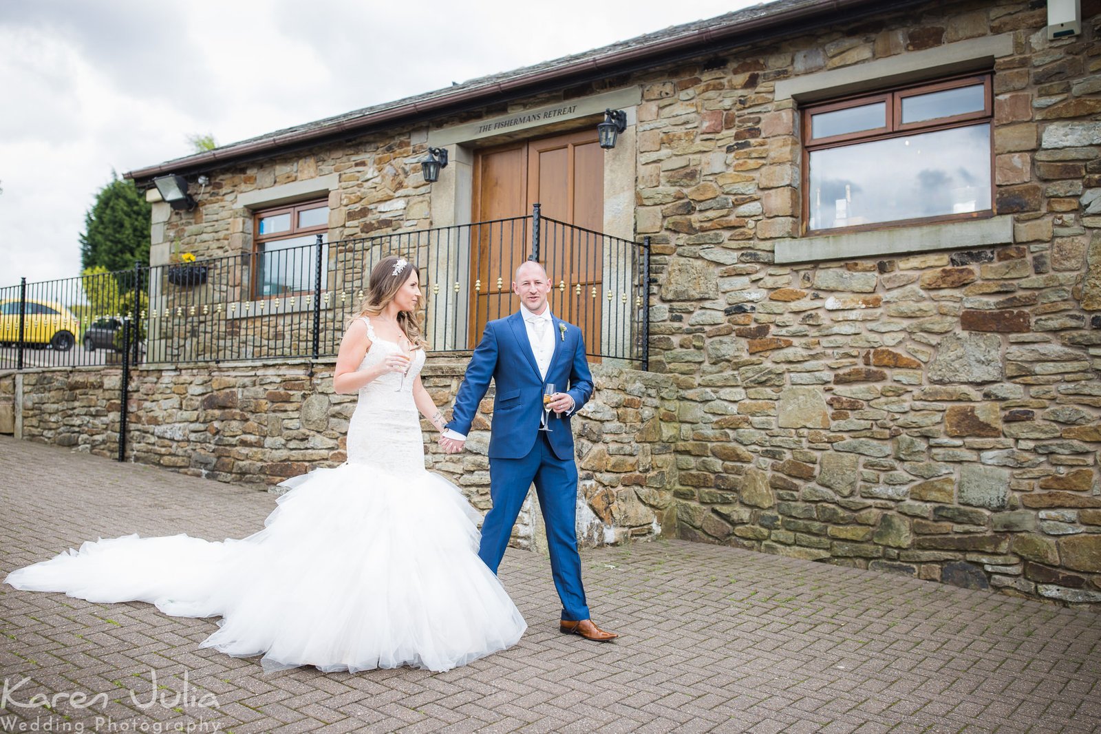 bride and groom walk hand in hand to meet wedding guests at the drinks reception