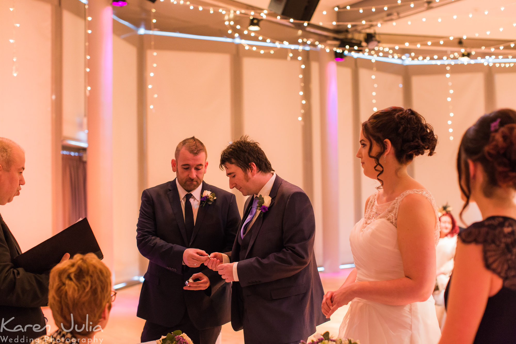 groom is given a ring by the best man during Lowry Theatre wedding ceremony