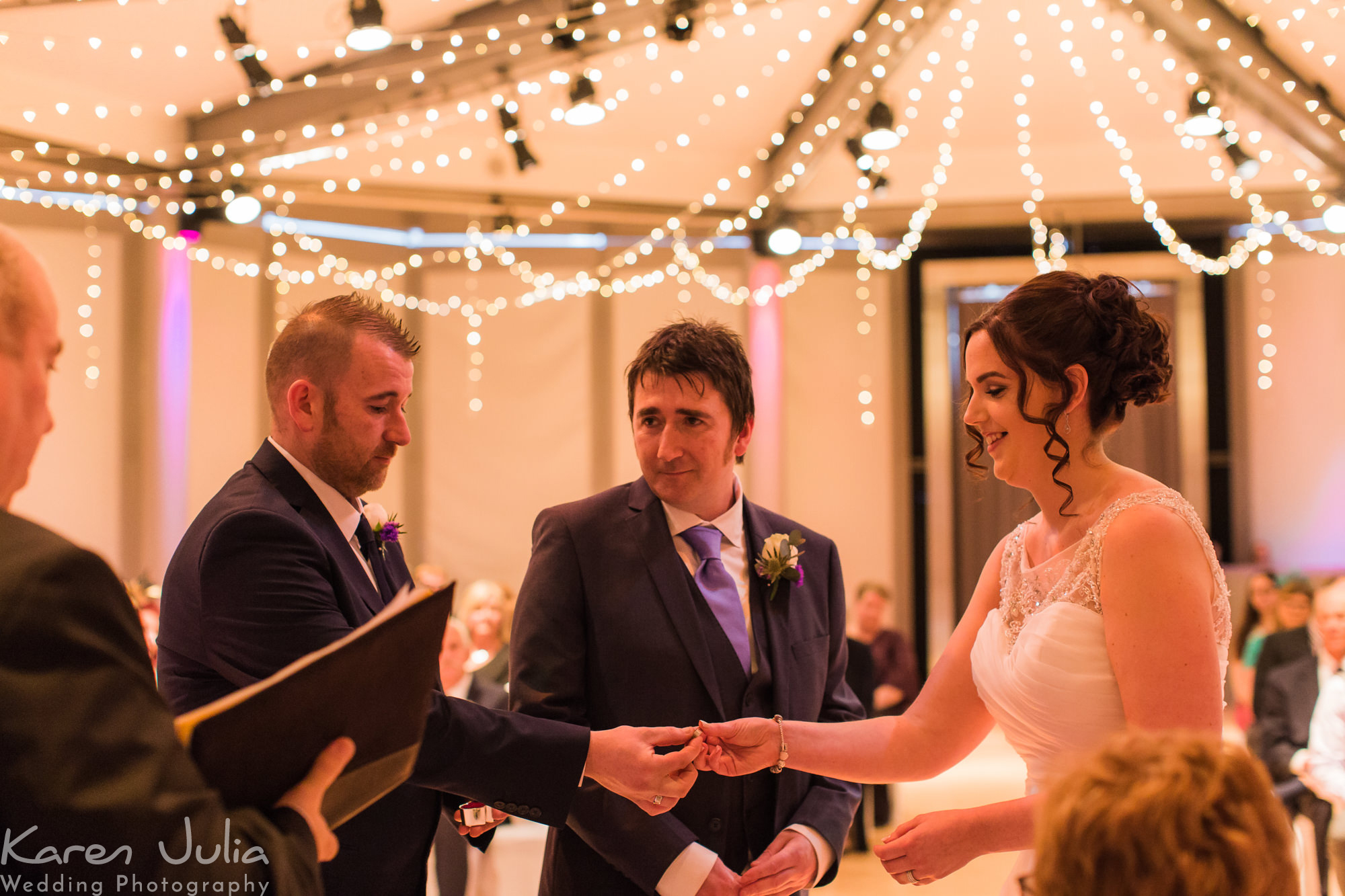 best man gives bride the ring for groom during wedding ceremony
