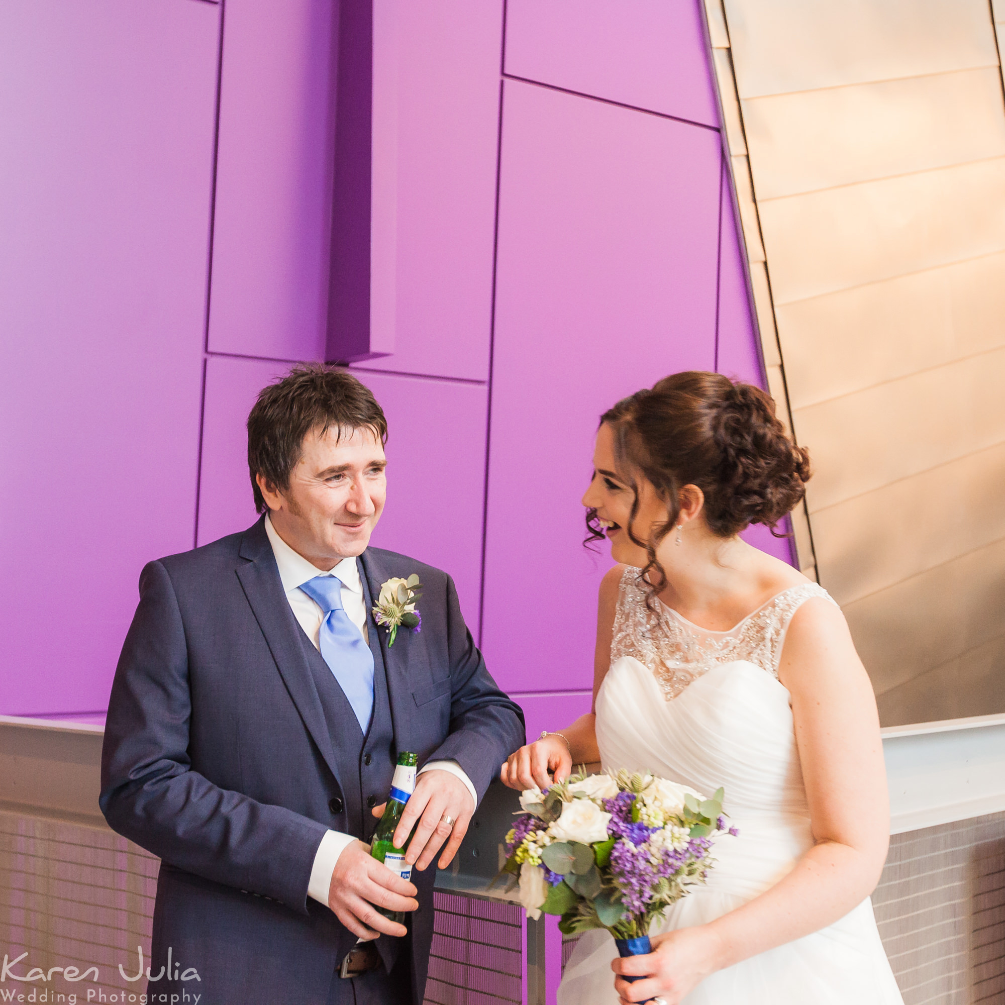 bride and groom portrait in front of purple wall at the Lowry Theatre