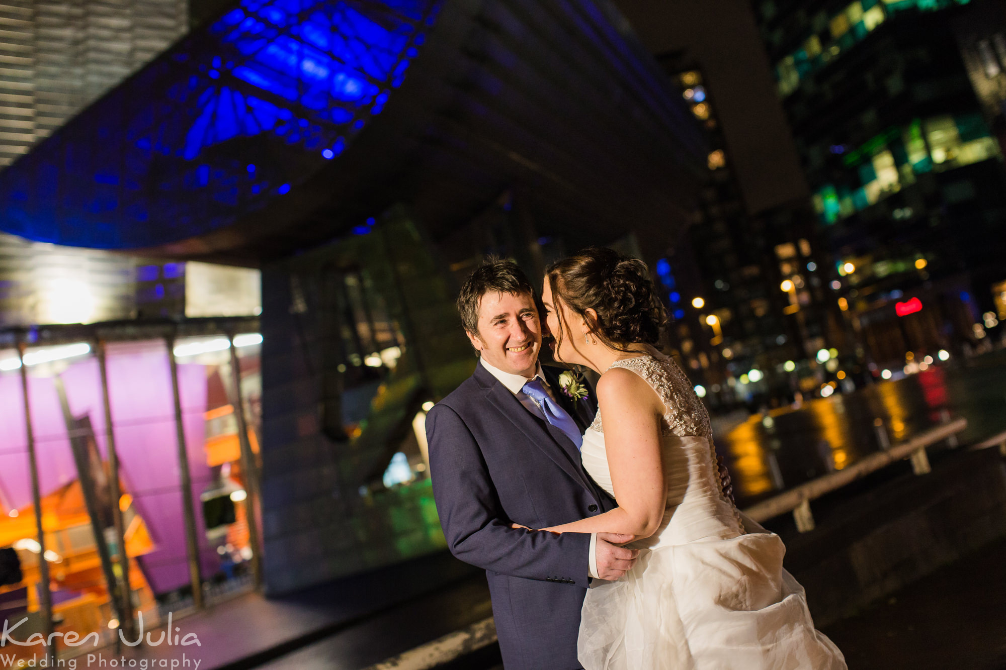bride and groom portrait at night with the Lowry Theatre in the background