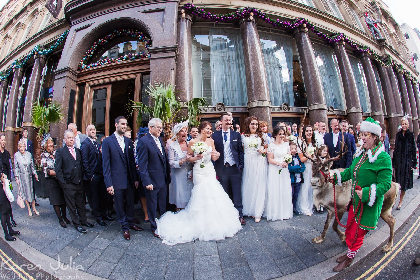 reindeer ar led to group of wedding guests for a photo