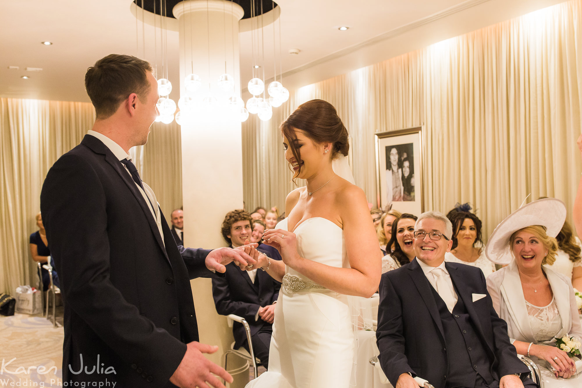 bride and groom exchange rings during wedding ceremony at the Hard Day's Night Hotel