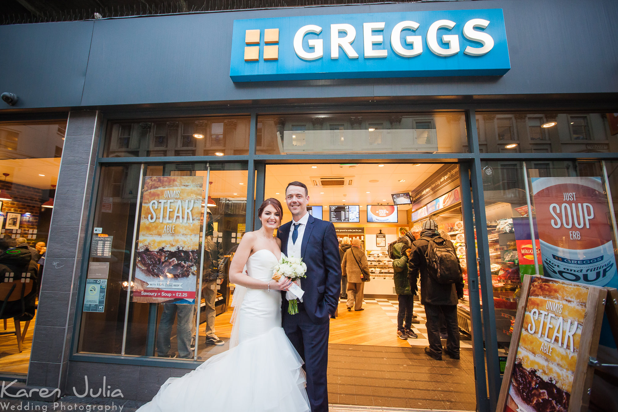 bride and groom portrait outside Greggs with a Greggs sausage roll