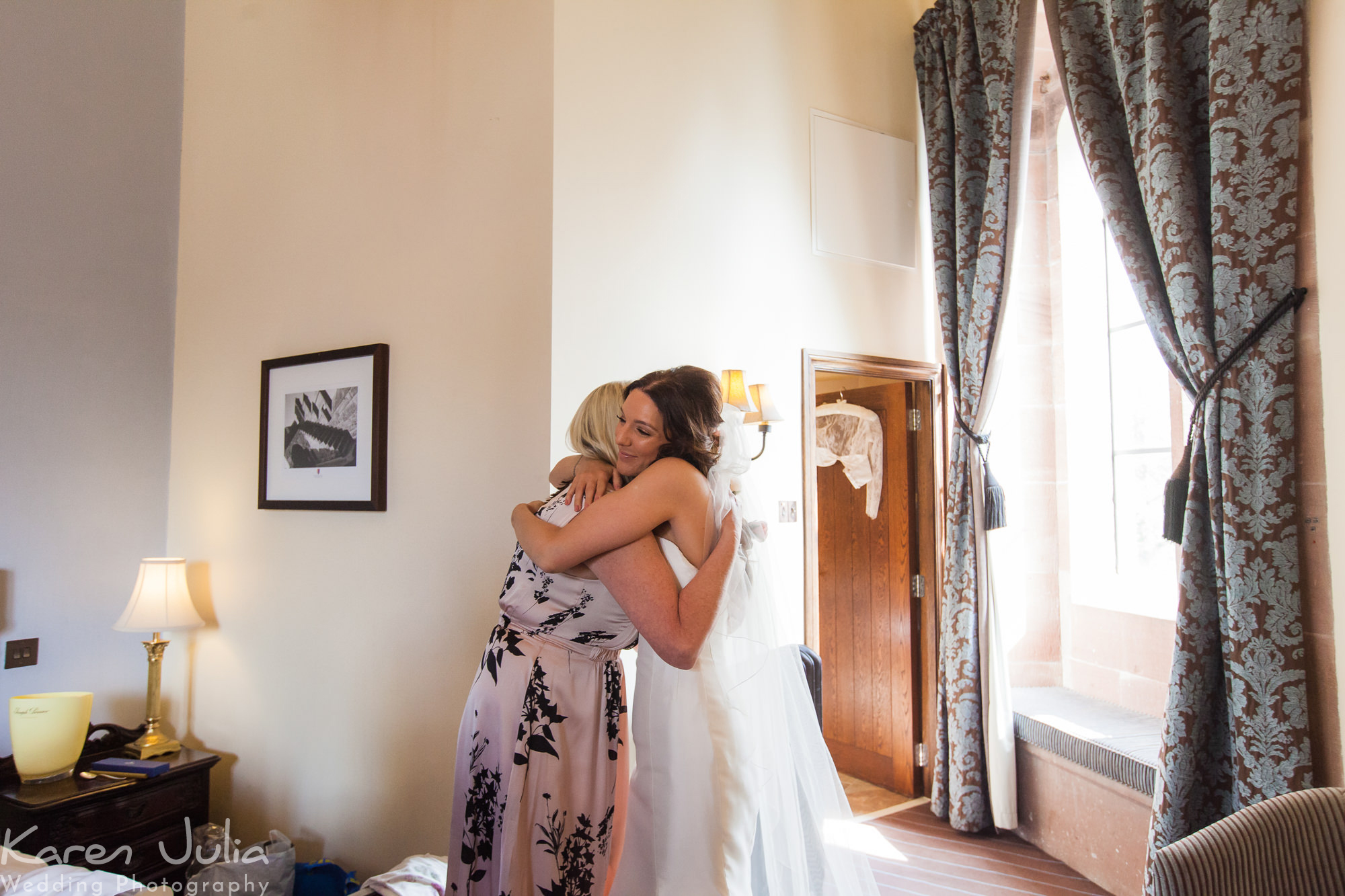 bride hugs mum after entrance in her wedding dress