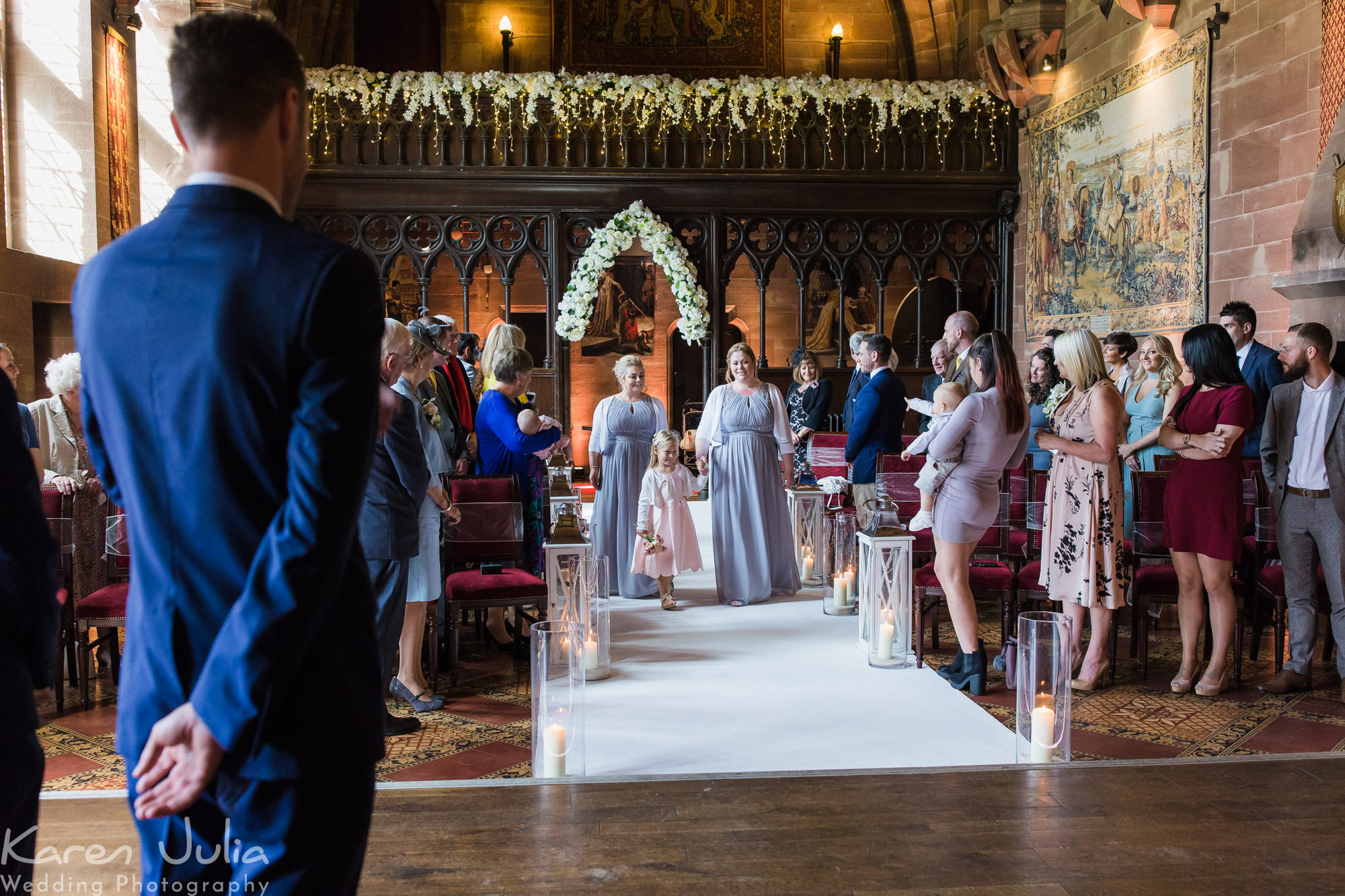 bridesmaids and flower girl walk down the aisle in the great hall