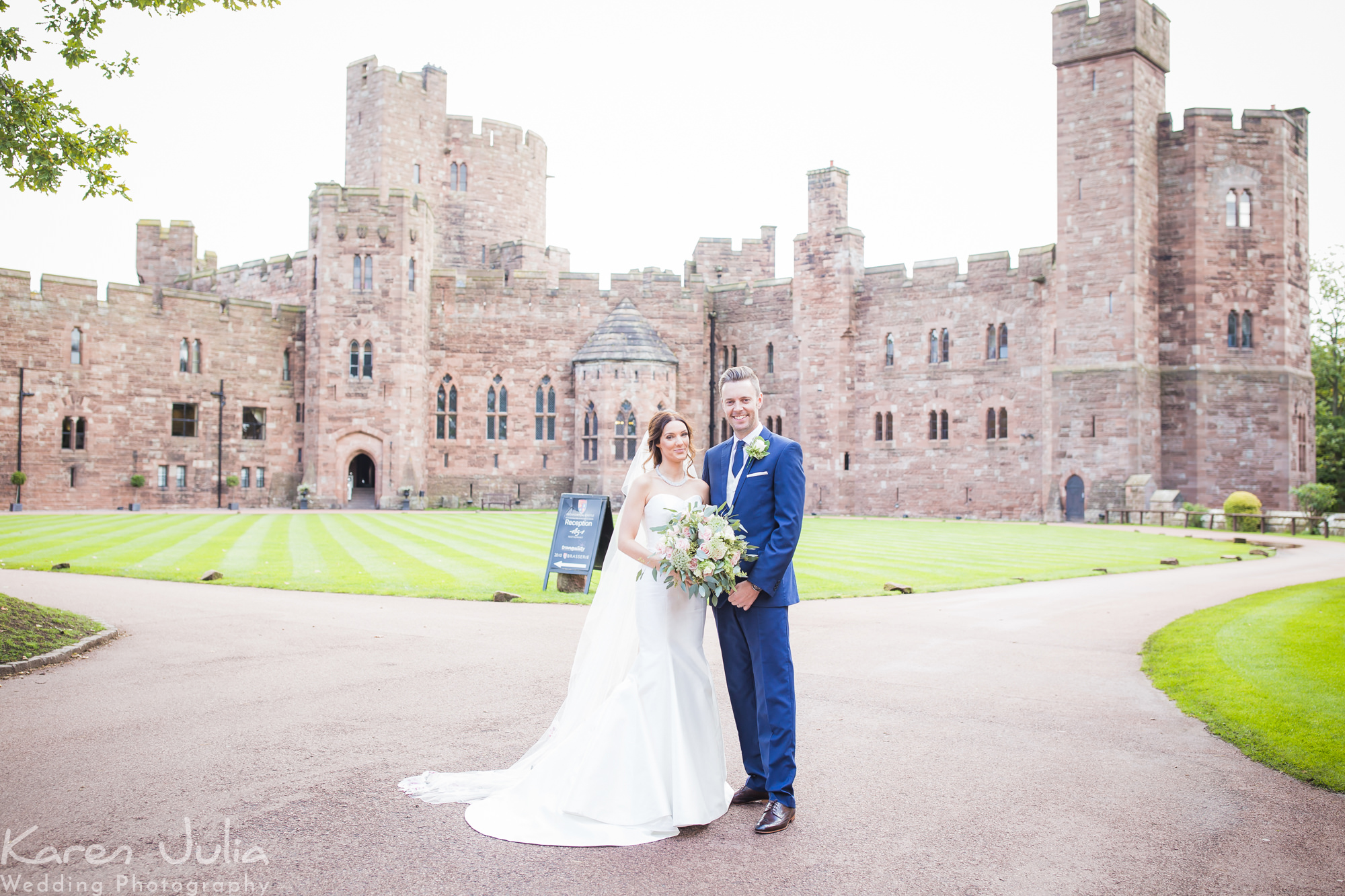 bride and groom portrait with Peckforton Castle in the background