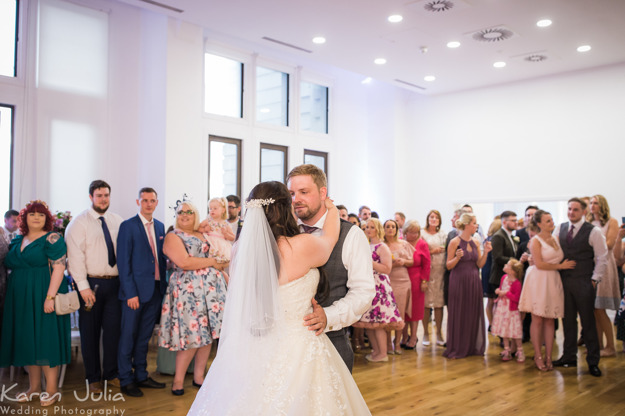 bride and groom have their first dance as guests watch at the Royal Liver Building