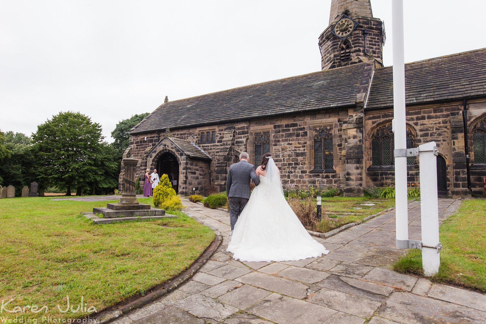 brie and father walk towards church before wedding ceremony