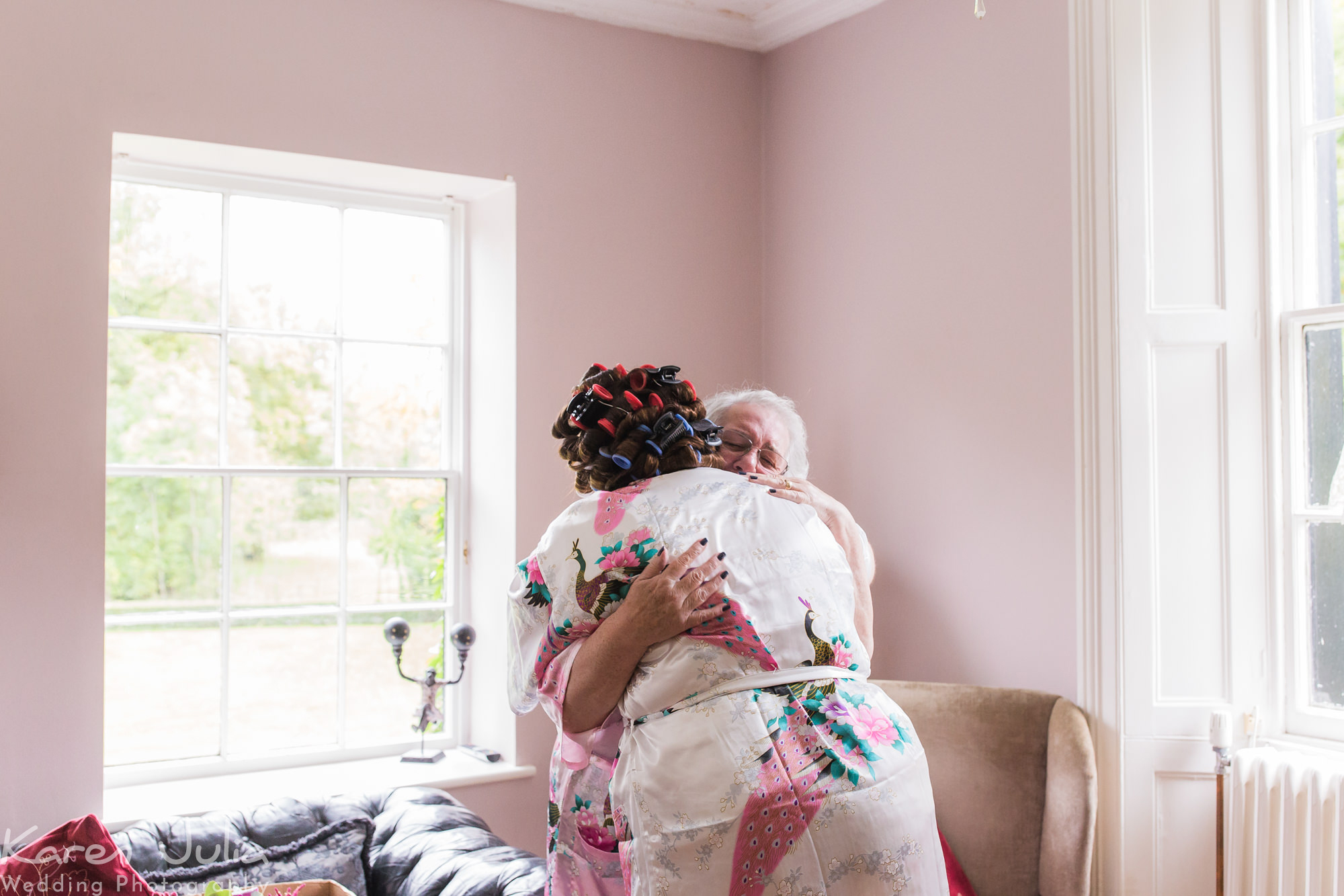 bride embraces relative with a hug during bridal preparations in the bridal suite at Statham Lodge Hotel
