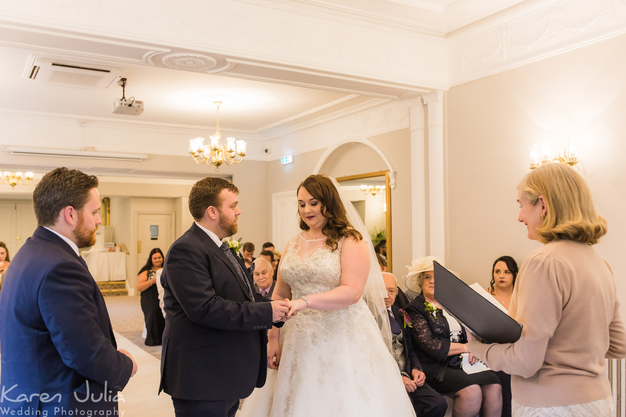 bride and groom exchange rings during wedding ceremony at Statham Lodge hotel