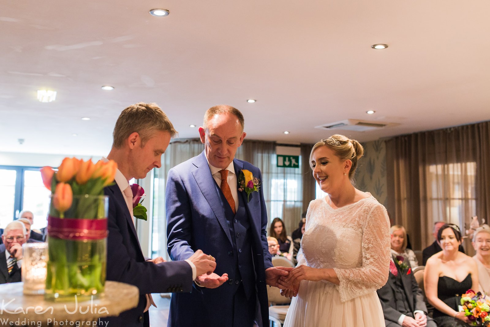 best man gives groom the wedding ring during the wedding ceremony