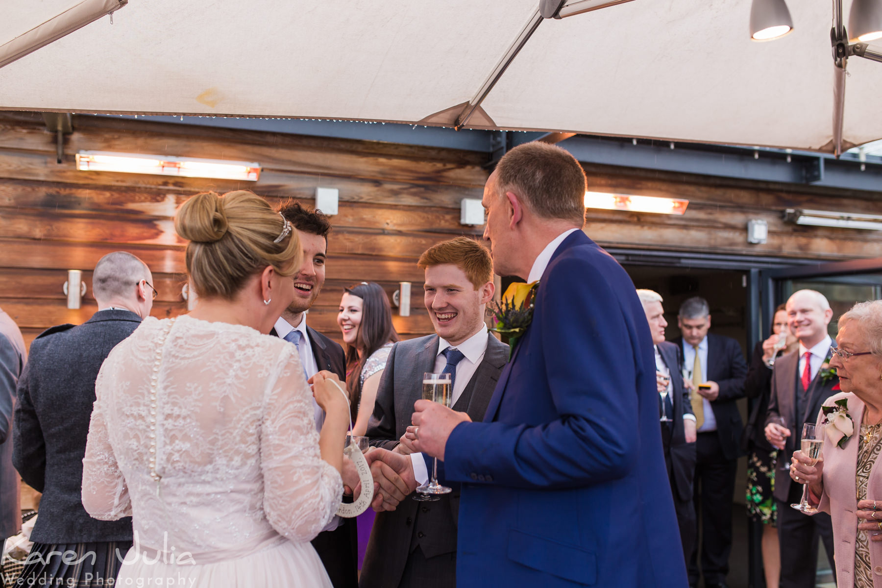 bride and groom are congratulated by guests during drinks reception