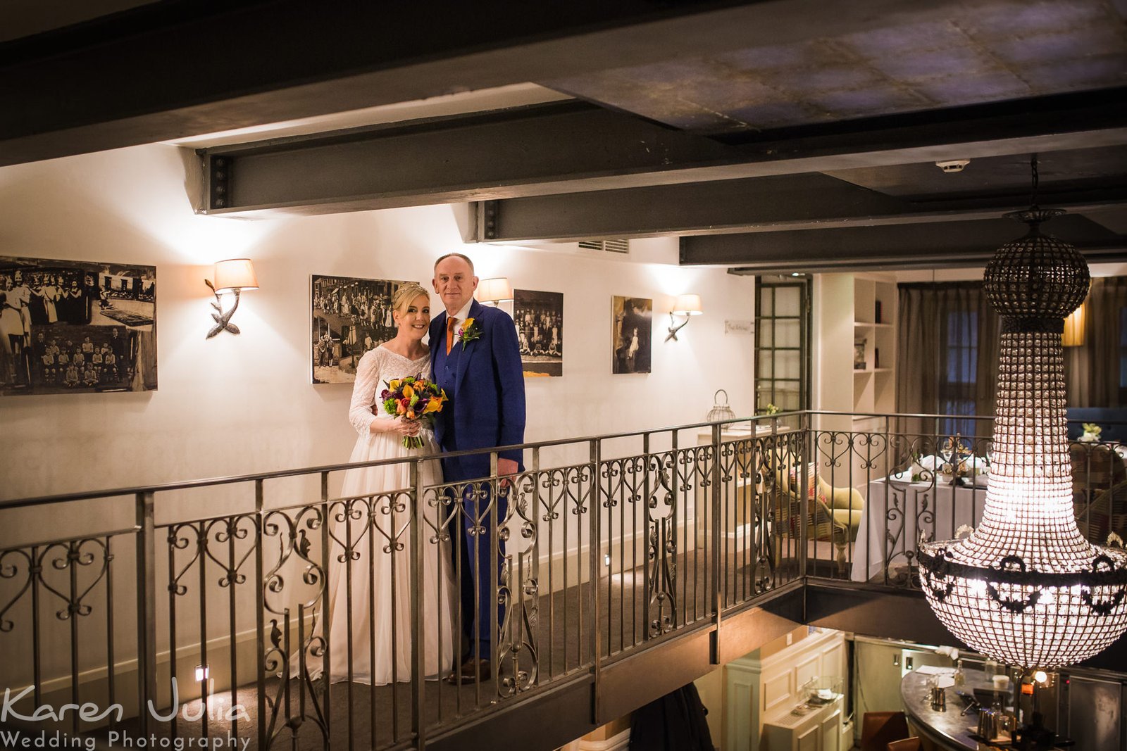 bride and groom portrait on the mezzanine level next to the chandeleir