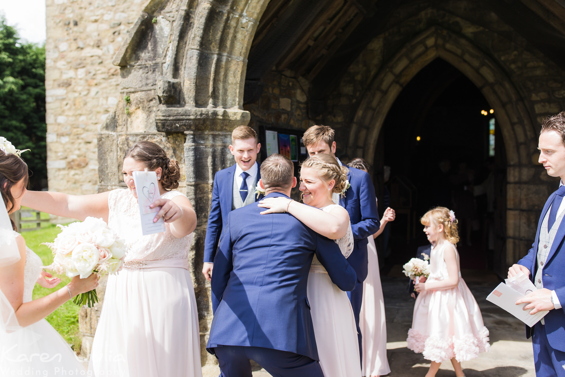 bride and groom are congratulated by guests outside the church