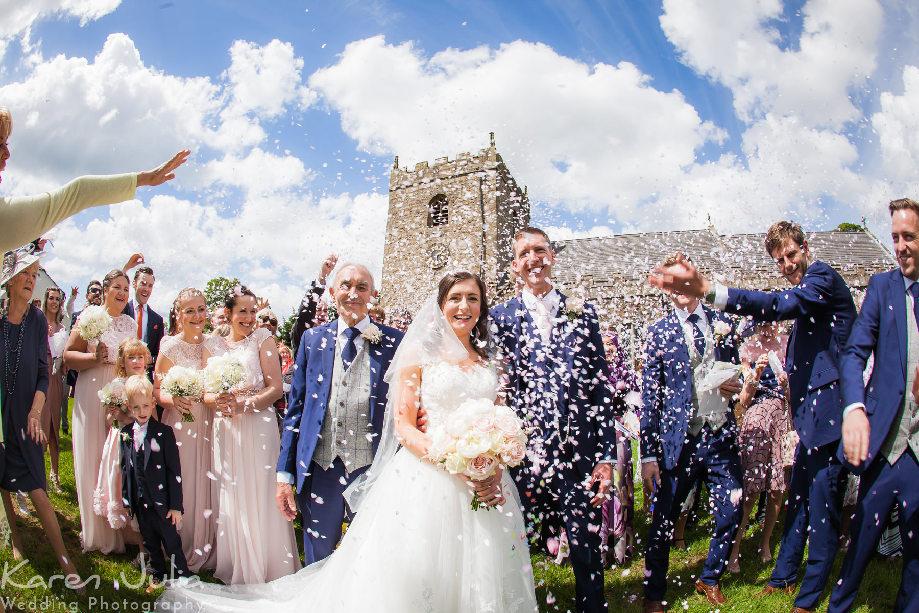 guests throw confetti and bride and groom outside the church