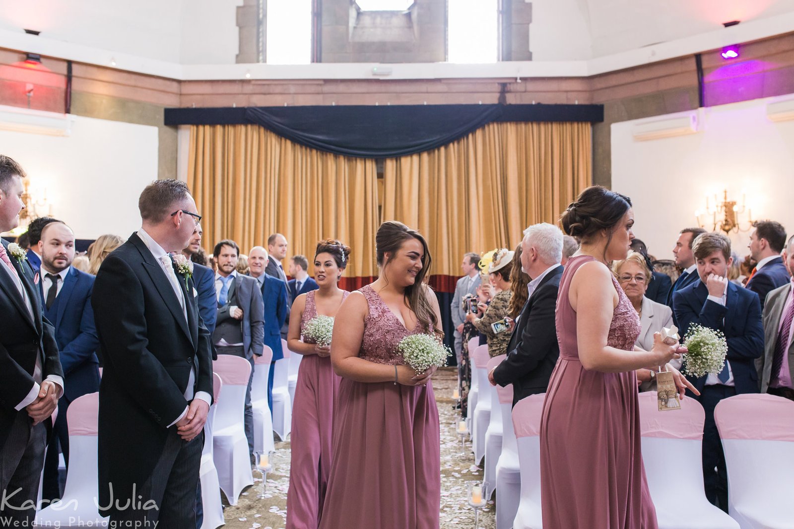 bridesmaids walk down aisle before wedding ceremony