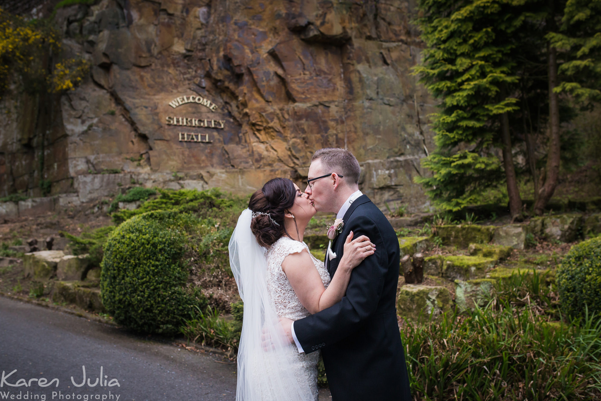 bride and groom portrait next to the Shrigley Hall welcome sign