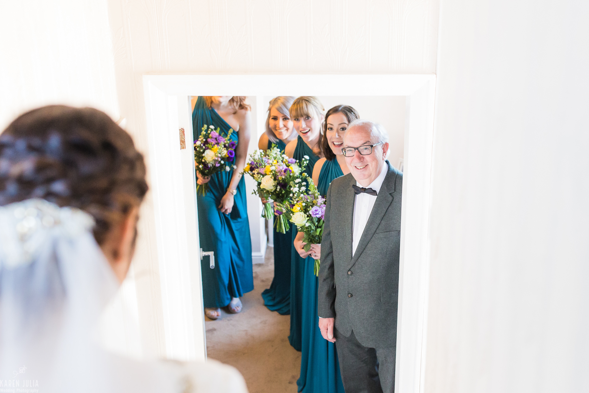 bride makes her entrance in dress and dad and bridesmaids look on