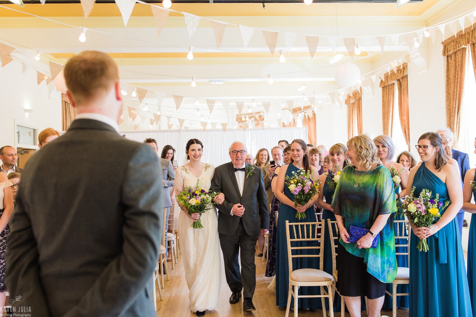 bride and her dad walk down the aisle towards groom