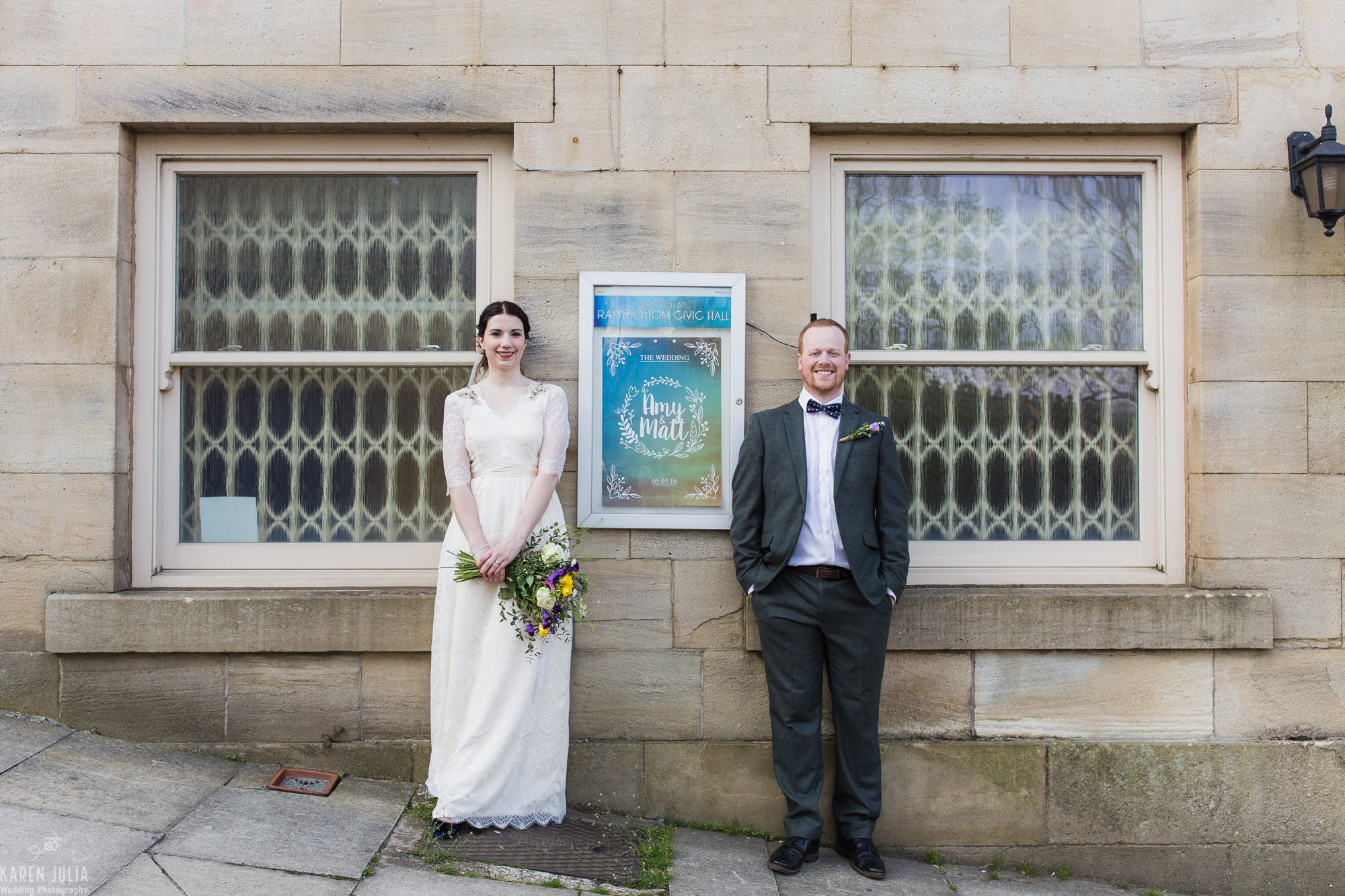 bride and groom portrait featuring event style poster at their wildflower Ramsbottom Civic Hall Wedding