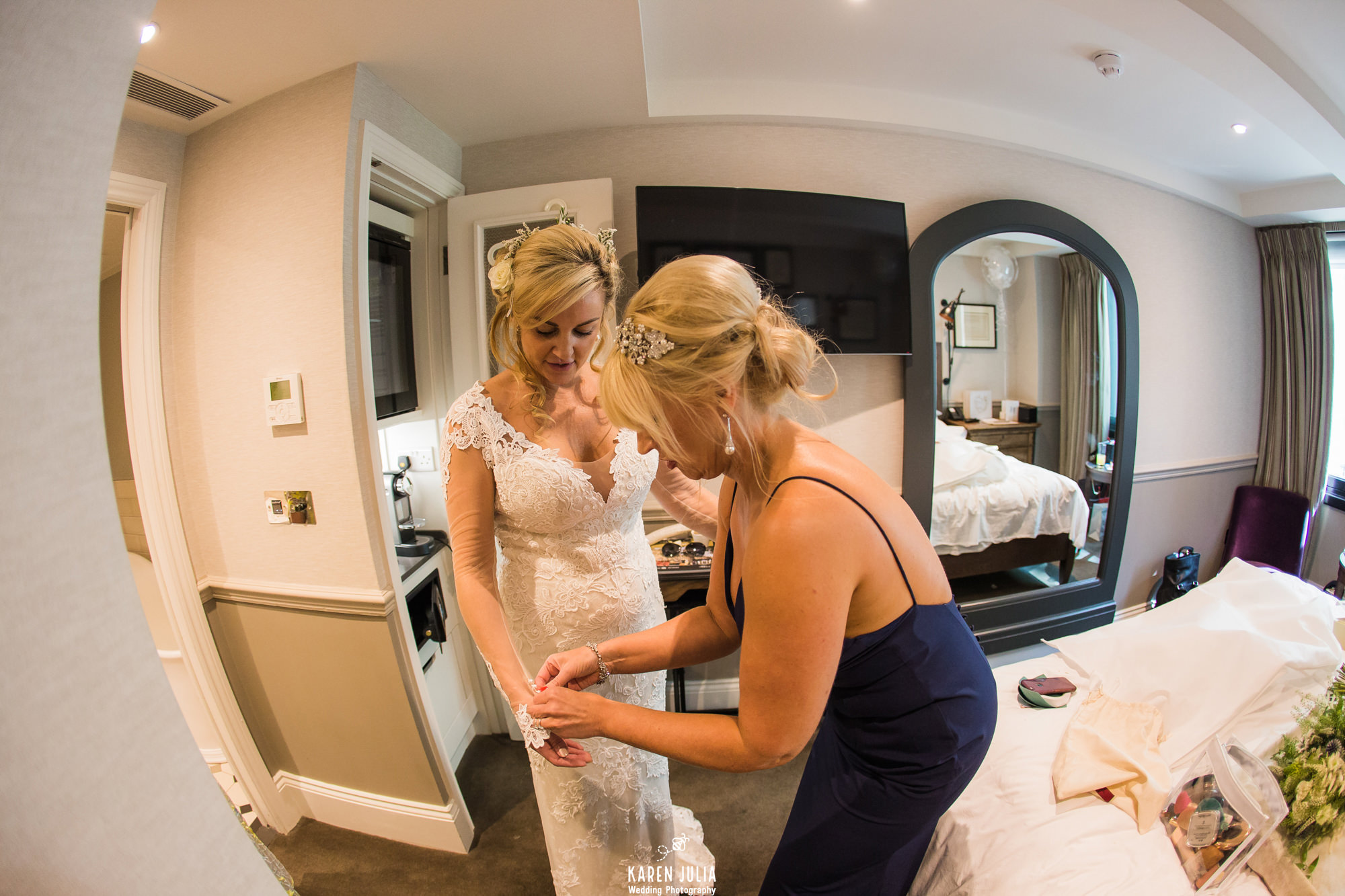 bridesmaid helps bride with jewellery before wedding ceremony at King Street Townhouse