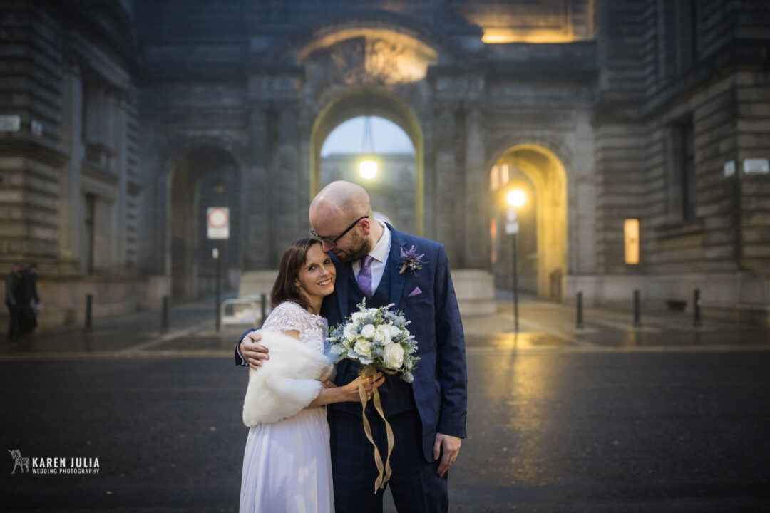 bride and groom have a wedding portrait with John Street and the city chambers in the background