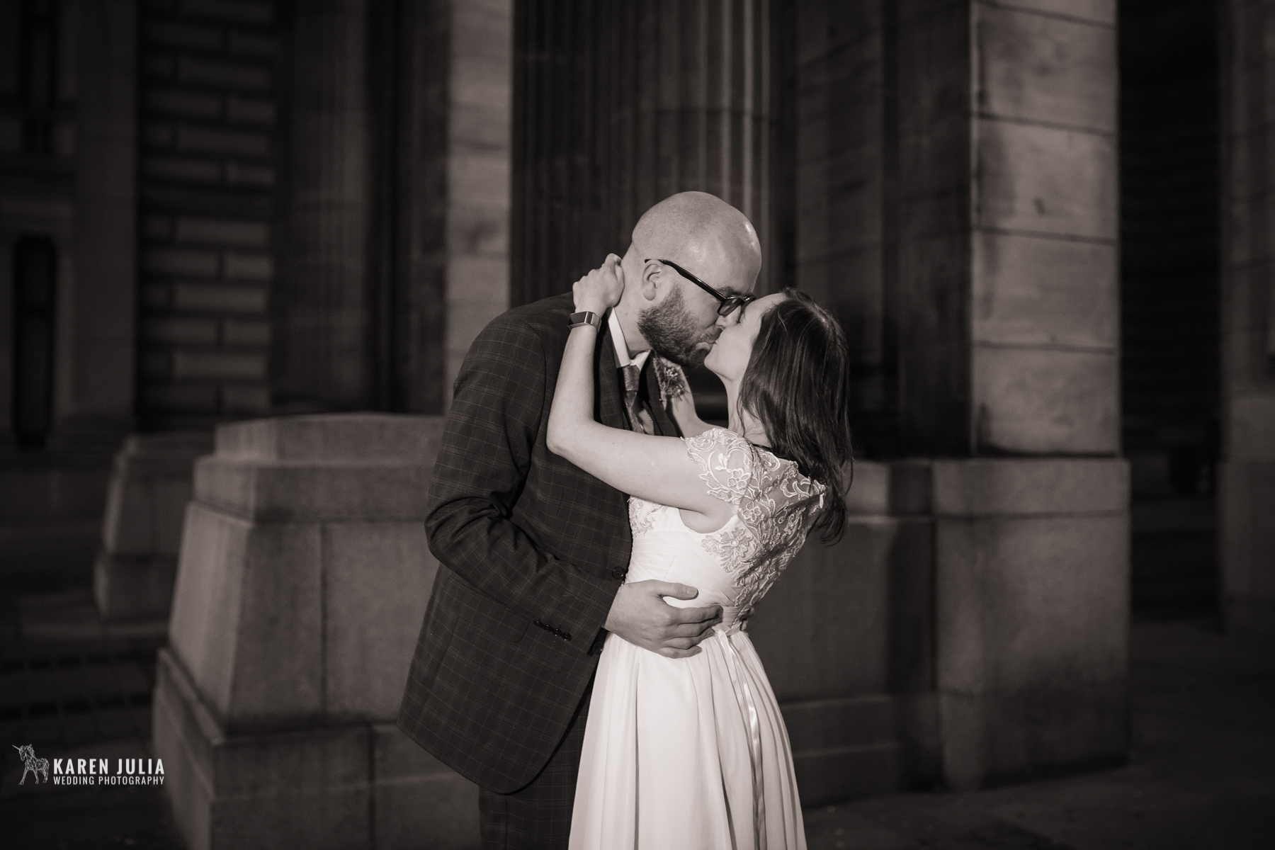 bride and groom embrace for a kiss during their urban city centre wedding portrait session.