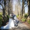bride and groom kiss in the tree lined walkway in Maxwell Park on their wedding day