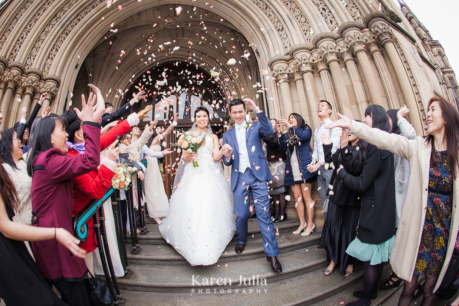 bride and groom walk down steps as guests throw dried flower confetti