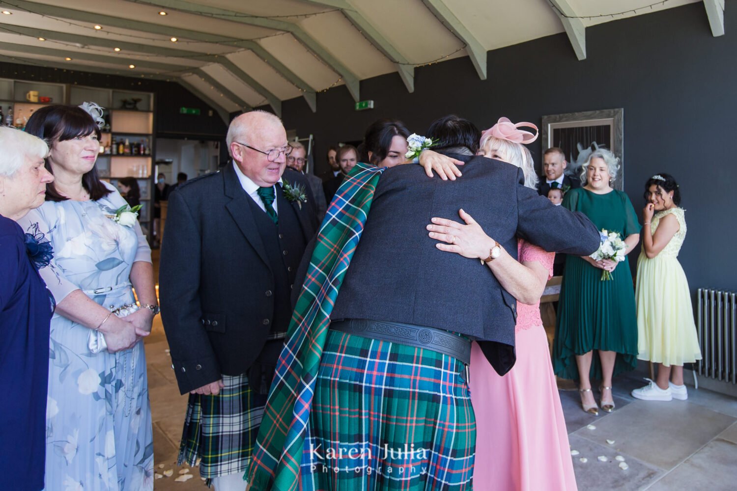 Groom hugs brides mum just before the wedding ceremony